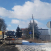 Zaśnieżone ulice, samochody z czapami śniegu na maskach, maszyny odśnieżające śnieg z ulic, chodników