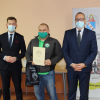 Zdjęcie - trzech mężczyzn stoi na tle baneru z herbem Murowana Goślina