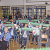 goście uroczystości z podniesionymi do góry klubowymi szalami