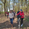 w trakcie spaceru, na pierwszym planie kobieta prowadząca rower