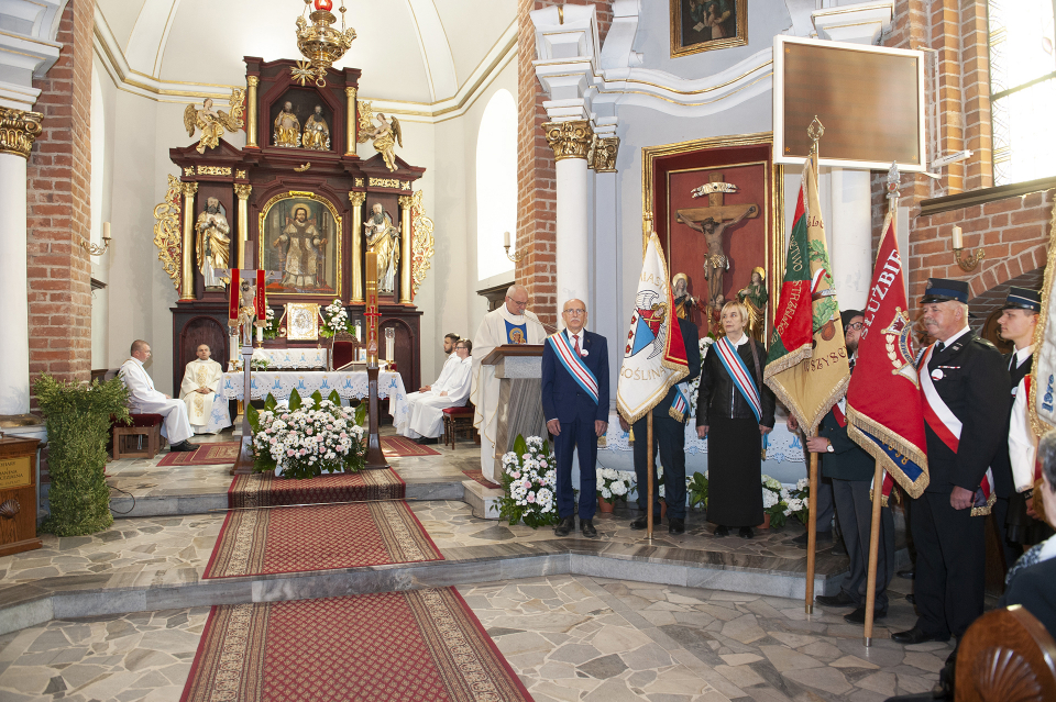 poczty sztandarowe przed ołtarzem w kościele