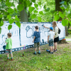dzieci malują na foliach rozciągniętych między drzewami