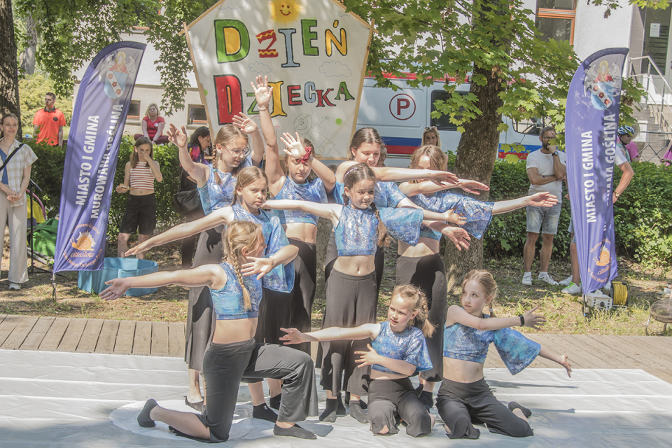 dziewczynki wykonują figurę akrobatyczną na deskach sceny w parku