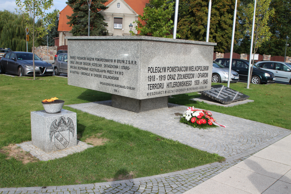 wiązanka kwiatów pod pomnikiem na pl. Powstańców Wlkp. w Murowanej Goślinie oraz płonący znicz