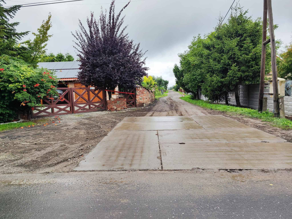 rozkopana ulica, po bokach budynki domów jednorodzinnych