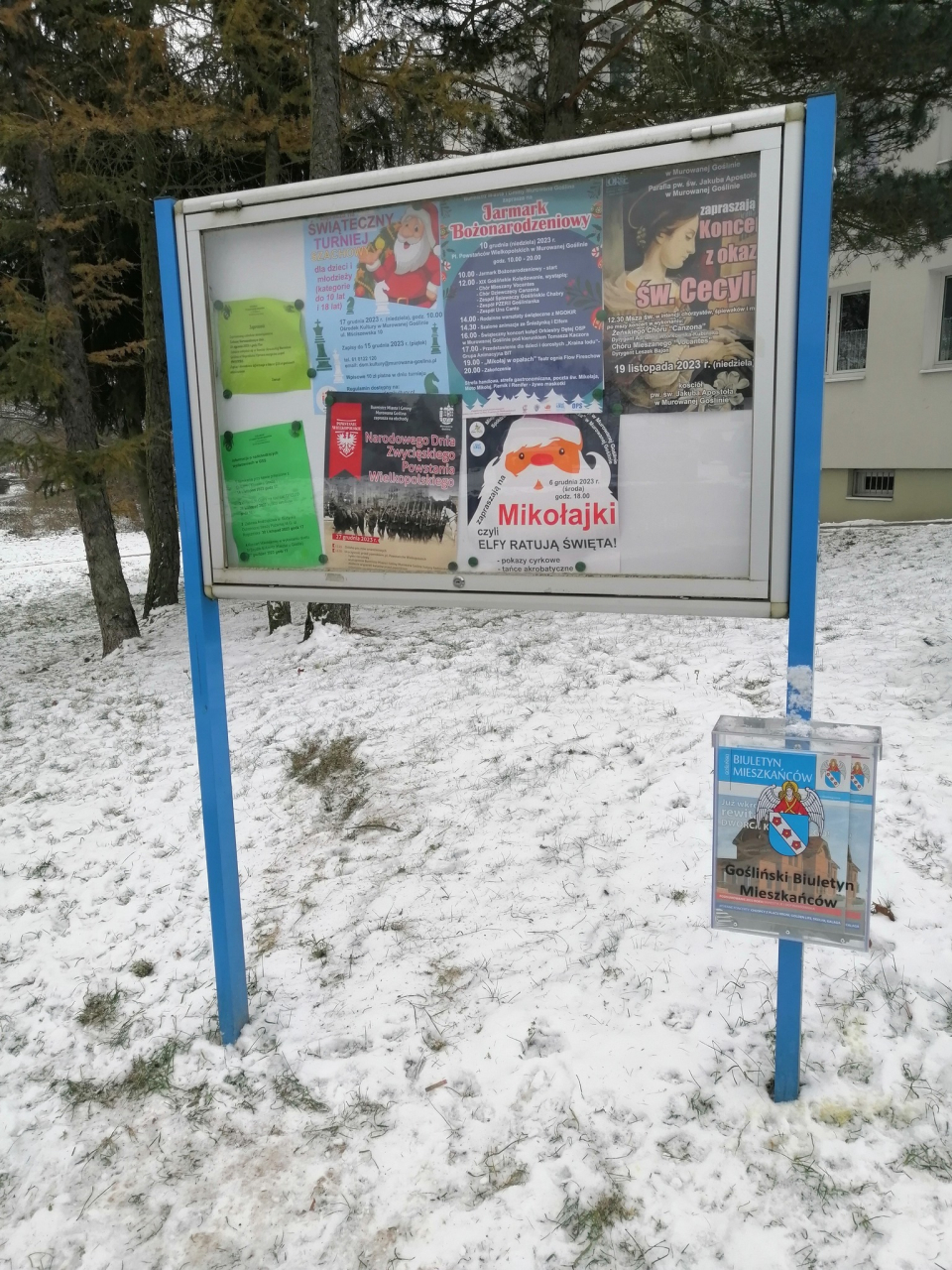 tablica informacyjna przy ulicy z doczepioną do nogi skrzynką na biuletyny