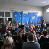 sala wypełniona widzami, w tle członkowie zespołu instrumentalnego