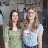 Artystki pozują do zdjęcia w tle publiczność i prace artystów