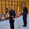 dwie policjantki stojące przed siedzącymi dziećmi