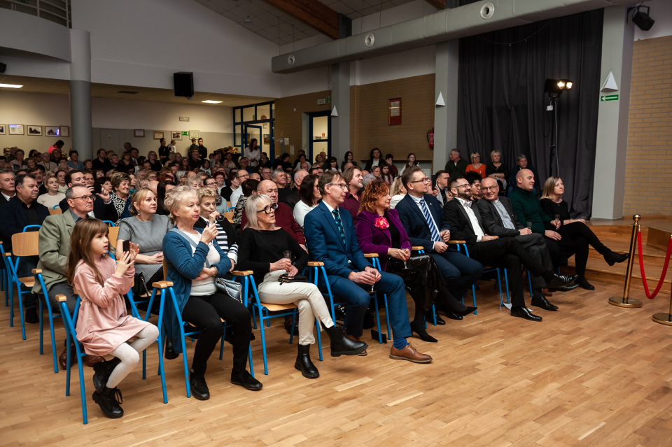 ludzie siedzący na krzesłach w sali