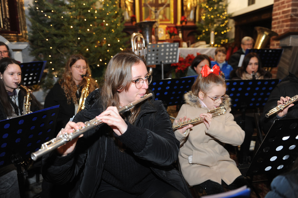 muzycy orkiestry grają koncert w kościele