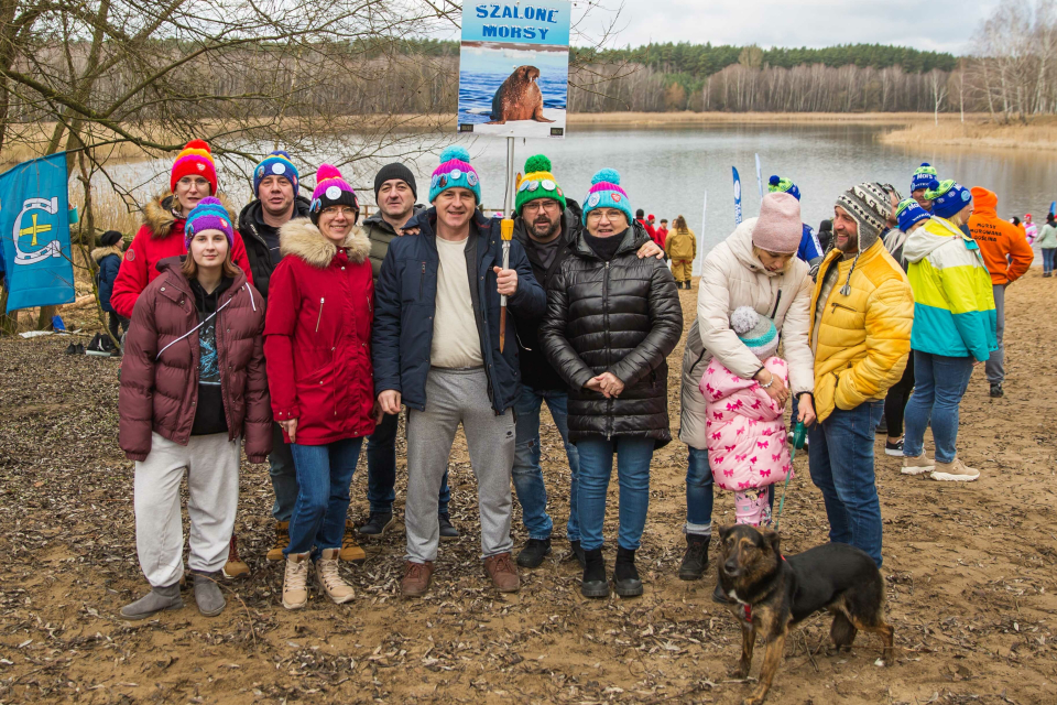 grupa ludzi pozuje na plaży do zdjęcia