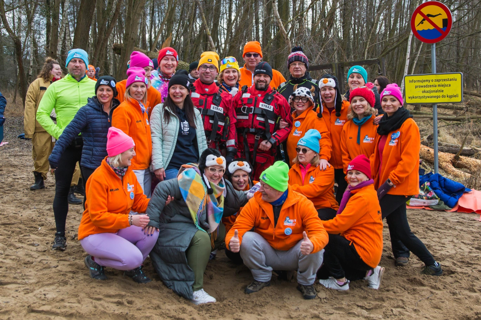 grupa ludzi pozuje do zdjęcia na plaży