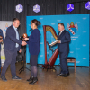 na scenie 5 osób, mężczyzna odbiera nagrodę na scenie z rąk kobiety