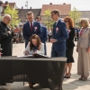kobieta dokonuje wpisu w księgę pamiątkową leżącą na stoliku na placu