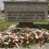 wiązanki z biało-czerwonych kwiatów pod pomnikiem