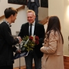 mężczyzna odbiera kwiaty i gratulacje od kobiety i mężczyzny