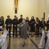 kobieta z mikrofonem, w tle chór