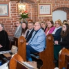 ludzie siedzący w ławkach w kościele