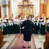 kobiety w chorze przed ołtarzem w kościele, przed nimi dyrygentka