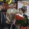 kobieta wręcza strażakom bukiet biało-czerwonych kwiatów