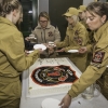 kobiety w strojach strażackich kroją jubileuszowy tort