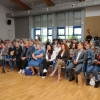 kobiety i mężczyźni siedzą na krzesłach na sali - publiczność