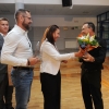 kobieta i mężczyzna wręczają kwiaty i gratulacje dyrygentowi chóru