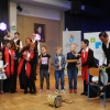 kilka osób z chóru wraz z dziećmi, które trzymają instrumenty muzyczne z Kolumbii