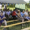 publiczność siedzi pod namiotem na ławeczkach