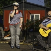 kobieta stoi na scenie śpiewa, mężczyzna siedzi obok i gra na gitarze