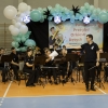 muzycy orkiestry dętej wraz z dyrygentem na hali widowiskowo-sportowej
