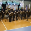 muzycy orkiestry dętej wraz z dyrygentem na hali widowiskowo-sportowej