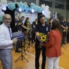 kobieta i dwóch mężczyzn wręczają kwiaty i upominek dyrygentowi orkiestry