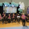 muzycy orkiestry dętej z dyrygentem na hali sportowej