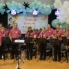 muzycy z orkiestry dętej wraz z kłaniającym się dyrygentem
