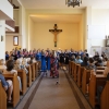 Chór przy ołtarzu oraz uczestnicy koncertu w ławkach.