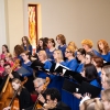 Muzycy grający na instrumentach oraz chóry przy ołtarzu.