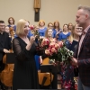 Organizatorzy wręczają kwiaty i statuetkę dyrygentce.
