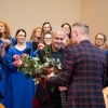 Organizatorzy wręczają kwiaty i statuetkę muzykowi.