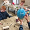 dzieci robiące papierowe balony przy stołach