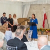 kobieta stoi przy mikrofonie, publiczność siedzi przed mówczynią