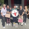 pięć kobiet, kobieta w środku trzyma tarczą strzelniczą
