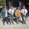 czterech mężczyzn, jedne z nich trzyma tarczę strzelniczą