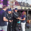grupa ludzi na scenie, kobieta gratuluje strażakowi
