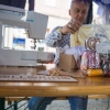 mężczyzna przy maszynie do szycia podczas przeróbki ubrań