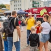 grupa ludzi wokół mężczyzny z mikrofonem na placu