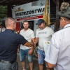 grupa ludzi odbiera nagrody przy podium