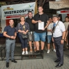 grupa ludzi z nagrodami na podium