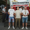 trzech mężczyzn pozuje do zdjęcia z pucharem